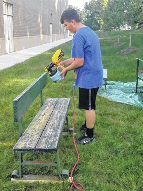 UHS student Kevin Bowdle paints a bench.